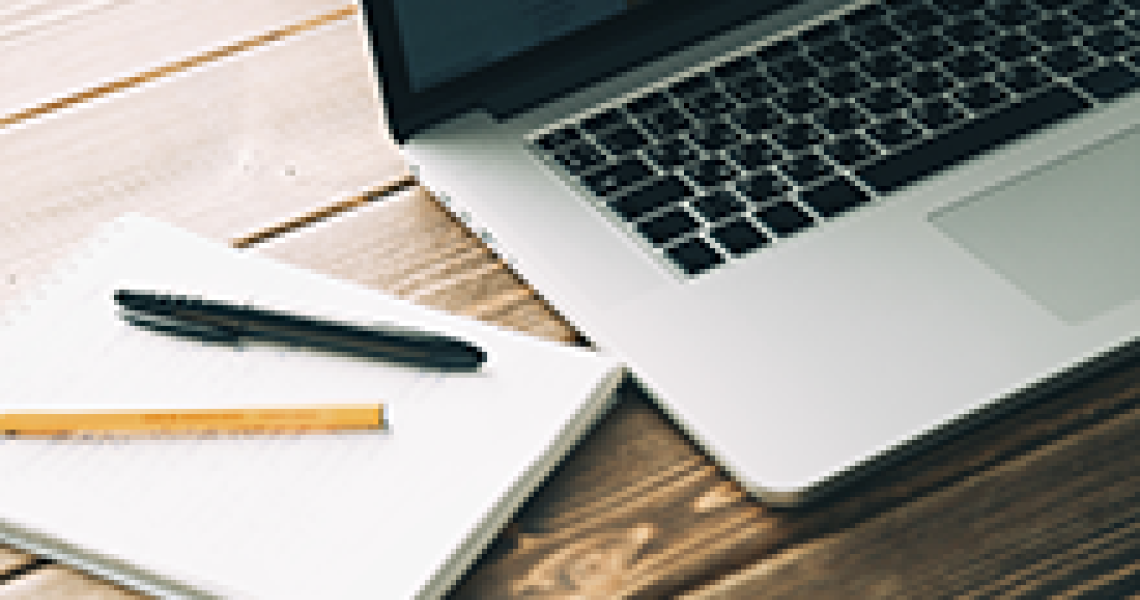 Notepad next to a laptop